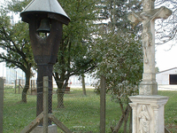 The wooden belfry and the stone cross in Ózaranypuszta